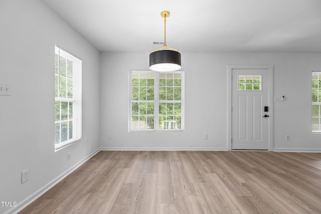 foyer featuring baseboards, light wood-style flooring, and visible vents