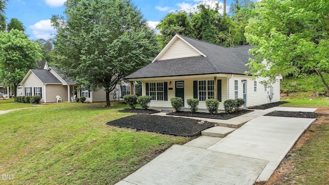 bungalow featuring covered porch, roof with shingles, and a front lawn
