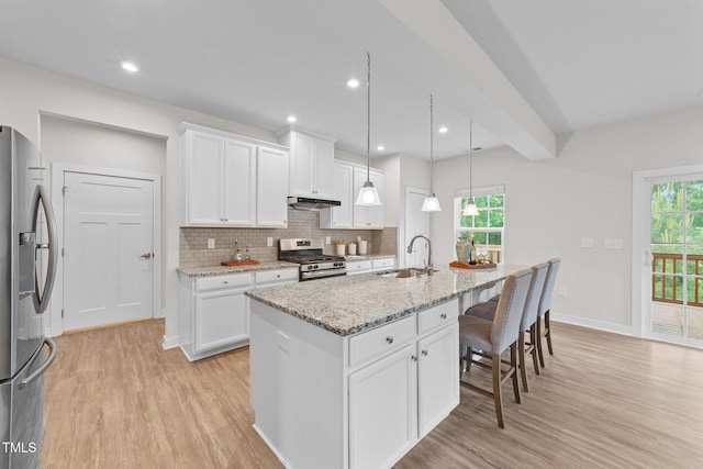 3700 Horton Hill Dr, New Hill, NC 27562 - kitchen with appliances with stainless steel finishes, light wood finished floors, a sink, white cabinetry, and recessed lighting