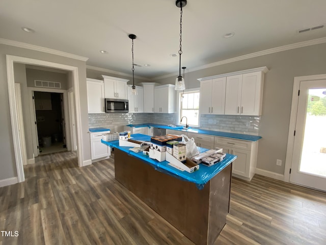 kitchen featuring stainless steel microwave, visible vents, and dark wood-type flooring