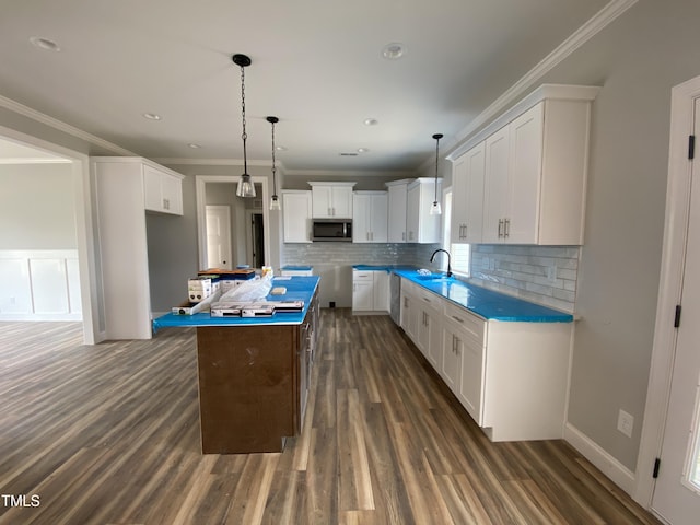 kitchen with stainless steel appliances, dark wood-style floors, a kitchen island, and a sink