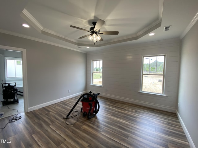 spare room with a ceiling fan, a healthy amount of sunlight, visible vents, and a raised ceiling
