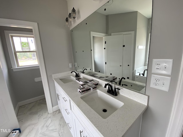 bathroom with marble finish floor, a sink, and double vanity