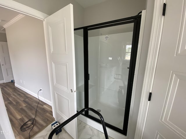 interior space with baseboards, a shower stall, and ornamental molding