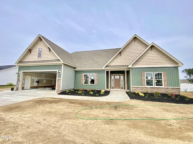 craftsman house featuring board and batten siding, driveway, and stone siding
