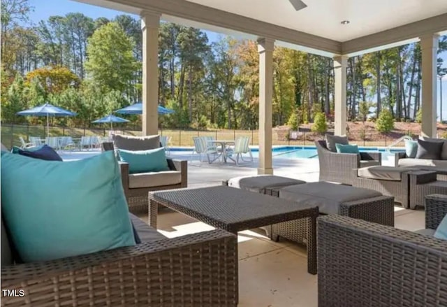 view of patio / terrace featuring an outdoor living space, an outdoor pool, ceiling fan, and fence