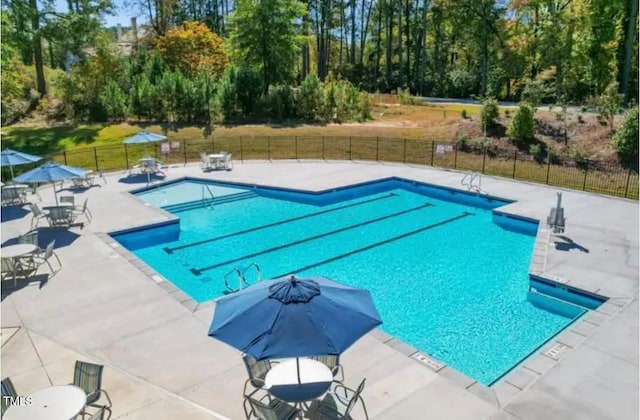 pool featuring fence and a patio area