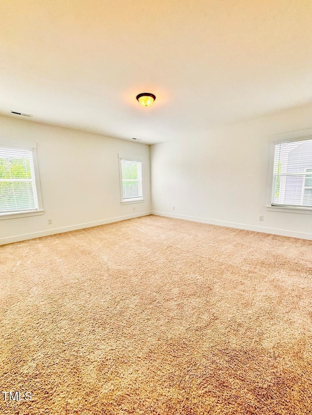 carpeted spare room with baseboards and visible vents