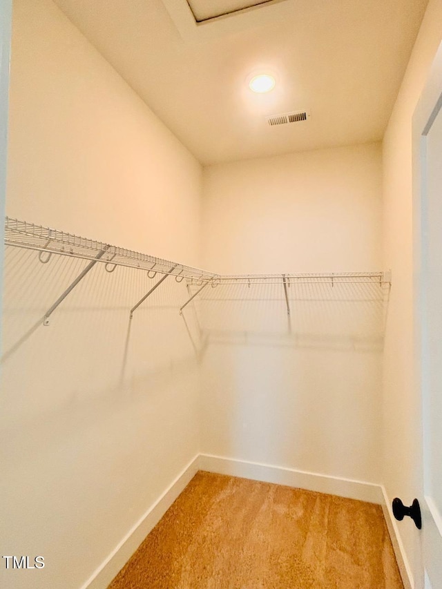 walk in closet featuring light carpet and visible vents