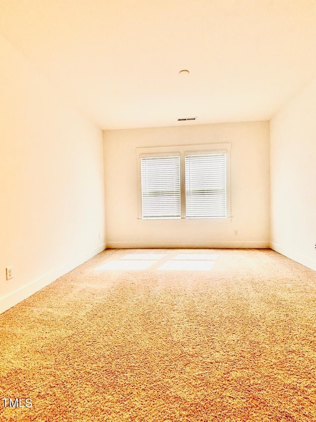 carpeted spare room with baseboards and visible vents