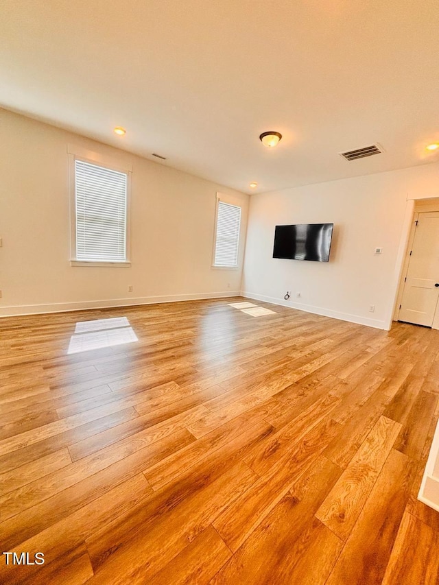 unfurnished living room with baseboards, light wood-type flooring, and visible vents
