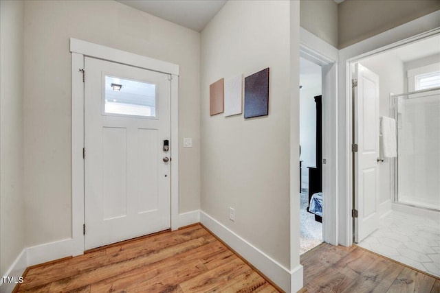 foyer with baseboards and light wood-type flooring