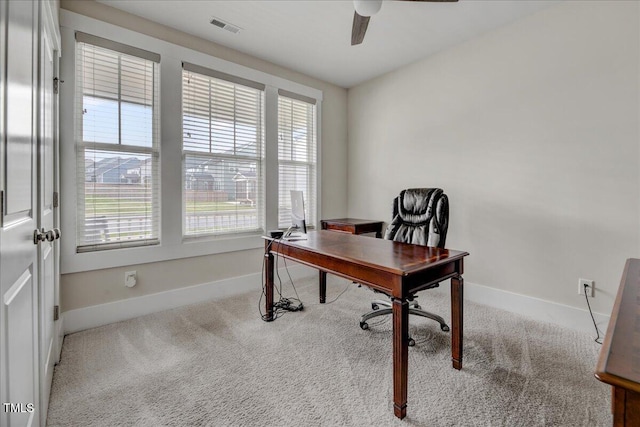 carpeted office with visible vents, baseboards, and ceiling fan