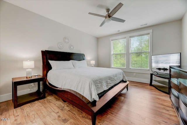 bedroom featuring baseboards, a ceiling fan, visible vents, and light wood-type flooring