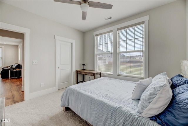 bedroom featuring carpet, visible vents, baseboards, and multiple windows