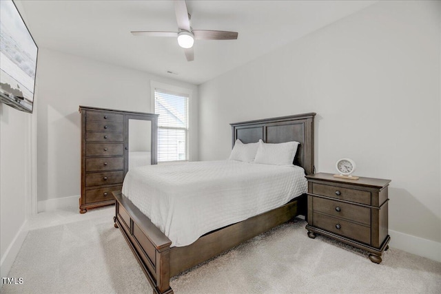 bedroom featuring baseboards, visible vents, light colored carpet, and ceiling fan