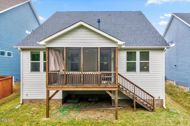 rear view of property featuring a lawn, a sunroom, and roof with shingles