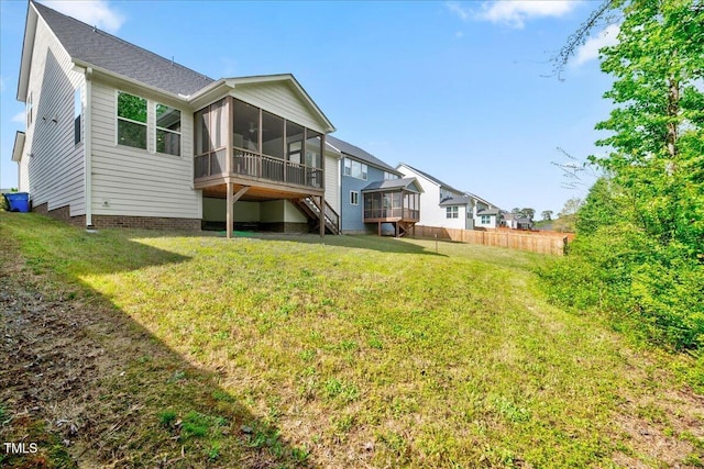 back of house with fence, a lawn, a sunroom, and stairs