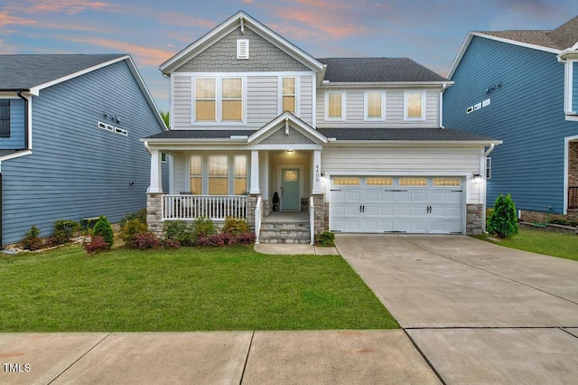 craftsman-style home featuring stone siding, concrete driveway, covered porch, an attached garage, and a front yard