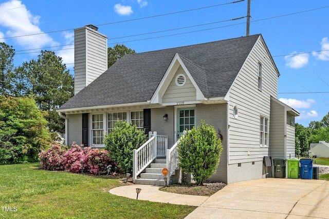 view of front of home featuring a front yard, a shingled roof, brick siding, and a chimney