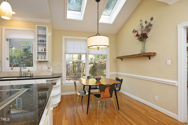221 Ironwoods Dr, Chapel Hill, NC 27516 - dining area with vaulted ceiling with skylight, light wood-style flooring, and baseboards