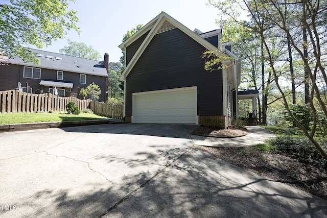 221 Ironwoods Dr, Chapel Hill, NC 27516 - view of side of property with a garage, aphalt driveway, and fence