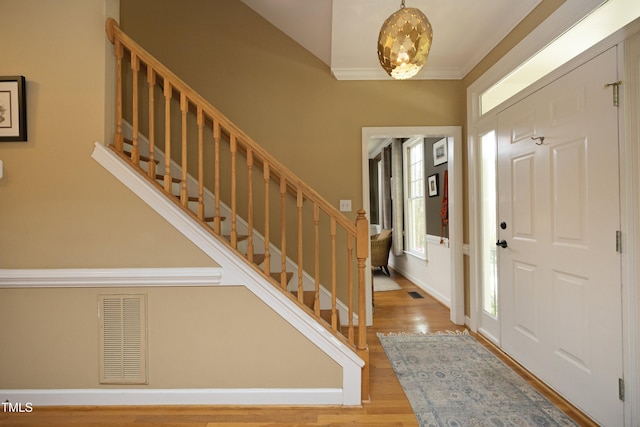 221 Ironwoods Dr, Chapel Hill, NC 27516 - foyer entrance featuring stairway, crown molding, wood finished floors, a notable chandelier, and visible vents