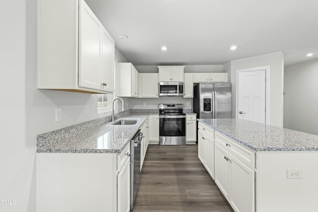 kitchen with white cabinetry, recessed lighting, a kitchen island, appliances with stainless steel finishes, and a sink