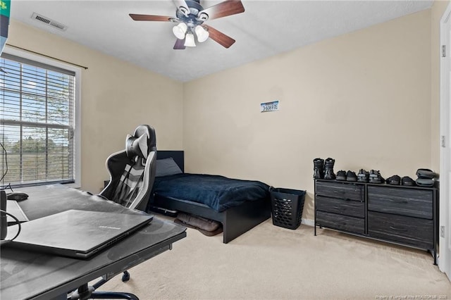 carpeted bedroom featuring visible vents and a ceiling fan
