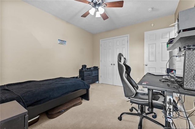 bedroom with light carpet, a closet, and a ceiling fan