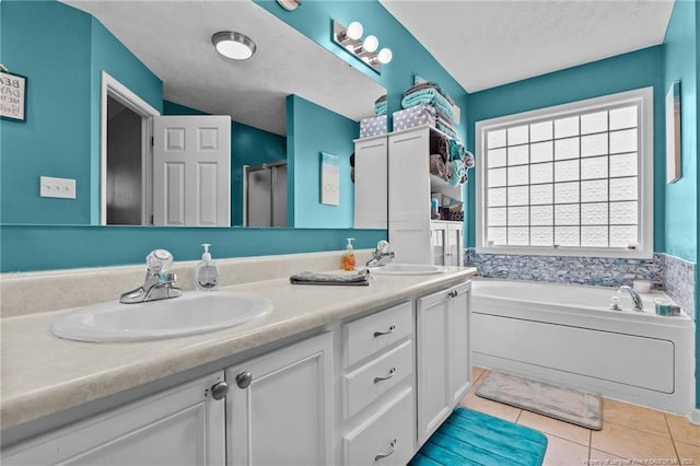bathroom featuring a garden tub, double vanity, a sink, and tile patterned flooring