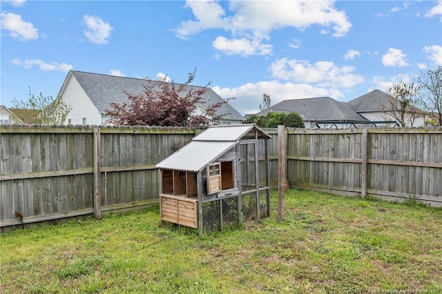 view of yard featuring a fenced backyard, exterior structure, and an outbuilding