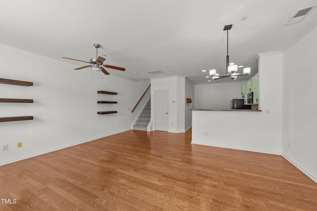 1120 Renewal Pl Unit 111, Raleigh, NC 27603 - unfurnished living room featuring stairway, a chandelier, a ceiling fan, crown molding, and light wood-style floors
