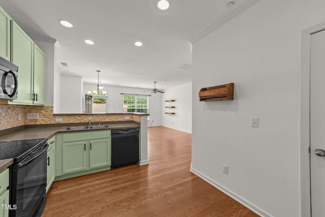 1120 Renewal Pl Unit 111, Raleigh, NC 27603 - kitchen with black appliances, green cabinets, a sink, a peninsula, and light wood-style floors