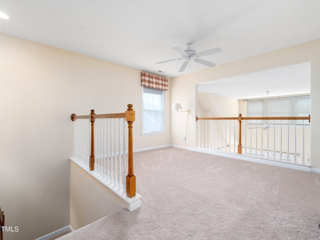 spare room featuring ceiling fan, carpet, and baseboards