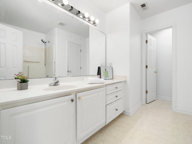 full bath featuring vanity, a shower, and baseboards