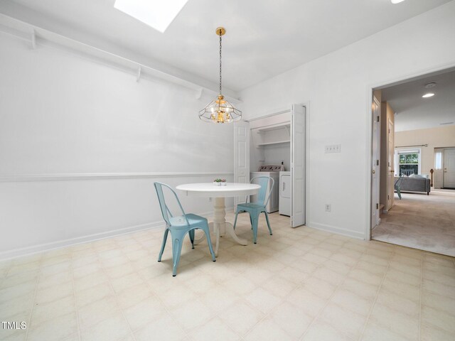 unfurnished dining area featuring washer and clothes dryer, light floors, a skylight, baseboards, and a chandelier
