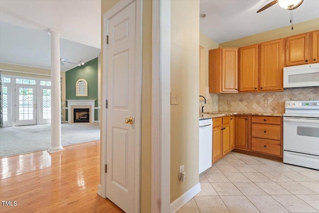 kitchen with a fireplace, ceiling fan, white appliances, and tasteful backsplash