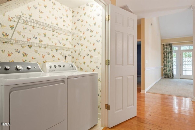 laundry room featuring laundry area, separate washer and dryer, light wood-style flooring, baseboards, and wallpapered walls