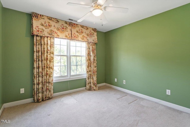 spare room featuring ceiling fan, carpet flooring, baseboards, and visible vents