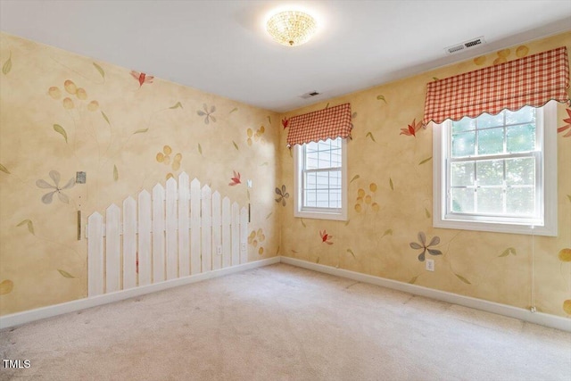carpeted spare room with visible vents and baseboards