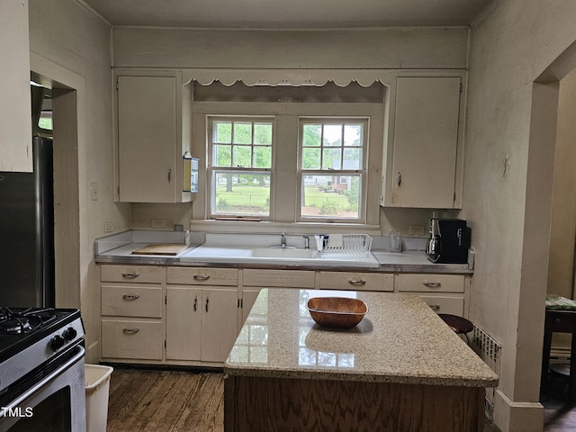 500 W Main St, Benson, NC 27504 - kitchen with dark wood-type flooring, stainless steel gas range oven, and a center island
