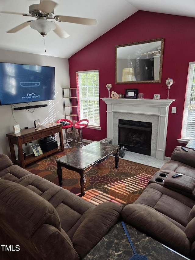 living area with lofted ceiling, a high end fireplace, a ceiling fan, and carpet floors