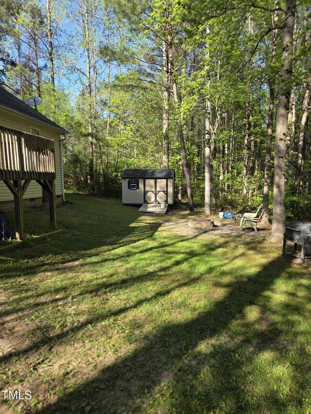 view of grassy yard with a storage shed and an outbuilding