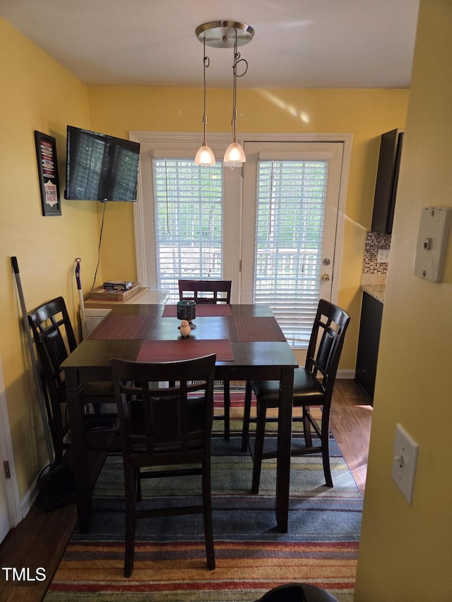 dining room with dark wood-type flooring and baseboards