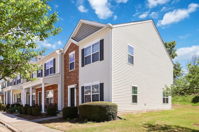 view of front of property featuring brick siding and a front yard