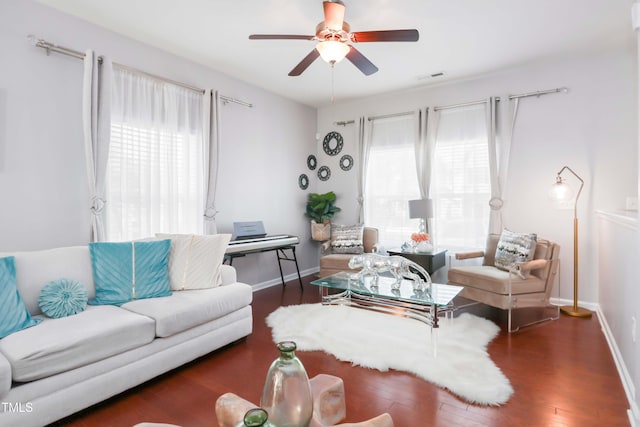 living room featuring wood finished floors, a wealth of natural light, ceiling fan, and visible vents