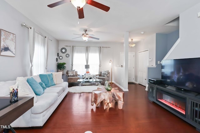 living area featuring wood finished floors, a ceiling fan, and baseboards