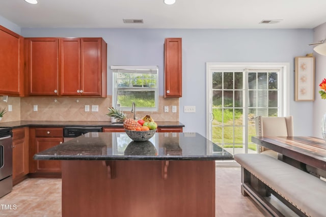 kitchen with dark stone counters, a center island, visible vents, and recessed lighting
