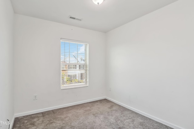 spare room featuring baseboards, visible vents, and carpet floors